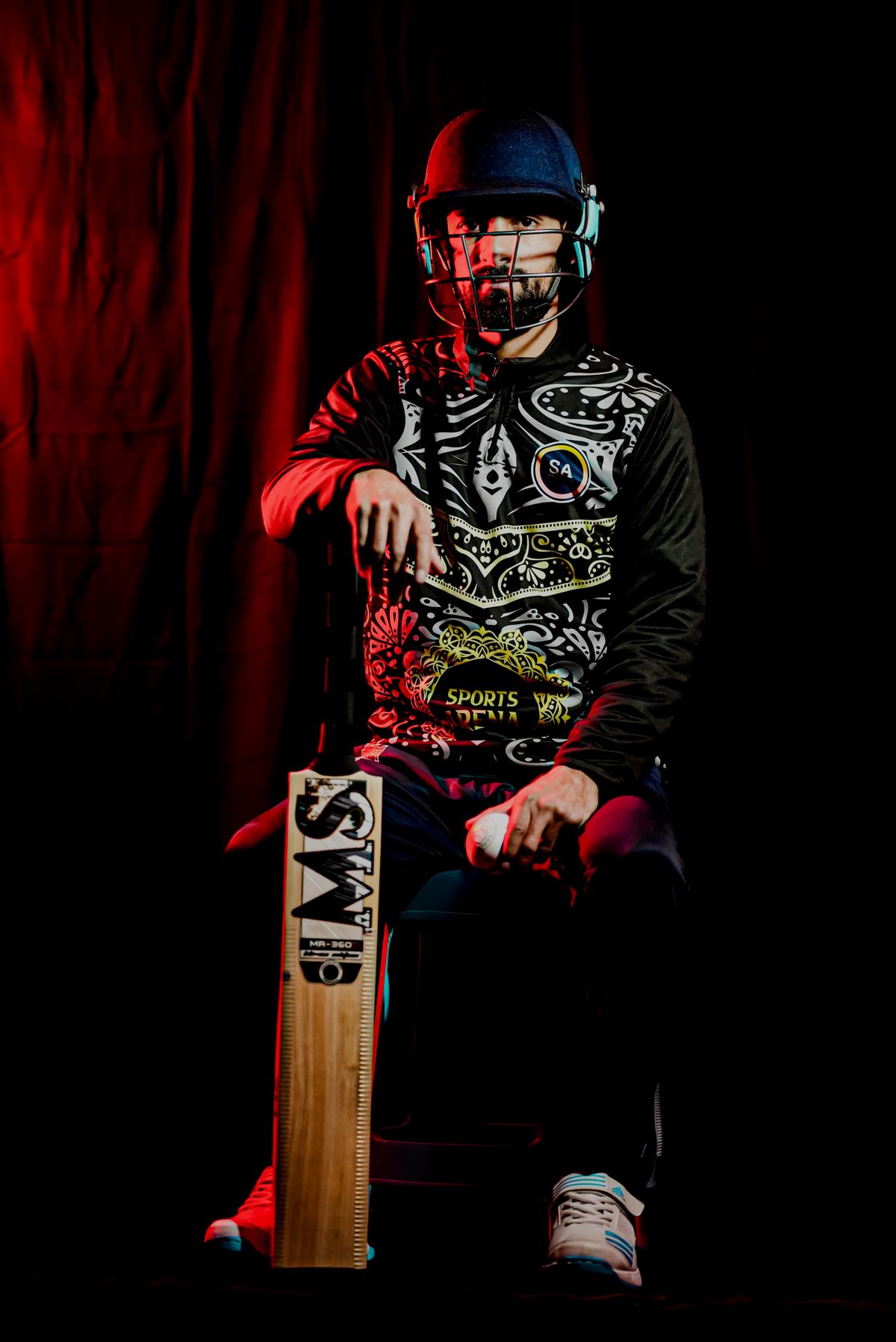 Cricket player holding a bat in full protective gear
